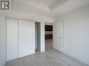 Toronto (Waterfront Communities) condo for rent - A room with white walls and a wooden floor with a sliding door.