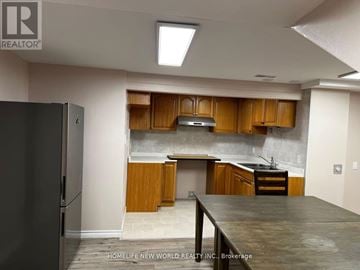Mississauga (Erin Mills) apartment for rent - A kitchen with wooden cabinets and a black refrigerator.