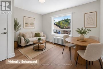 Grimsby (Grimsby East) apartment for rent - A living room with a couch, chairs, and a table with a vase of flowers on it.