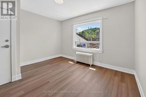 Grimsby (Grimsby East) apartment for rent - A room with a window showing a view of a house and trees outside.
