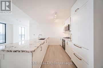 Toronto (Englemount-Lawrence) condo for rent - A white kitchen with a marble counter top and wooden floors.