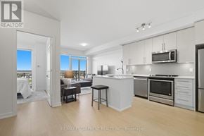 Mississauga (Central Erin Mills) condo for rent - A modern kitchen with stainless steel appliances and a dining table.