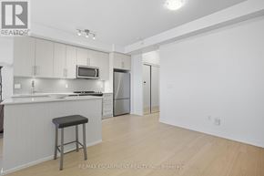 Mississauga (Central Erin Mills) condo for rent - A kitchen with white cabinets and a bar stool.