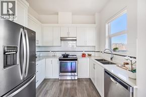 Maple Ridge apartment for rent - A modern kitchen with a stainless steel refrigerator and white cabinets.