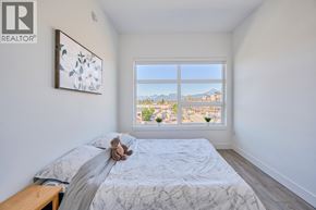 Maple Ridge apartment for rent - A bedroom with a large bed and a window overlooking a cityscape.