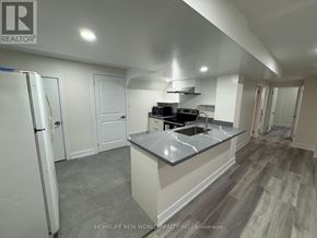 Toronto (Dorset Park) apartment for rent - A kitchen with a refrigerator, sink, and stove top.