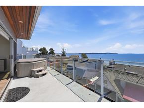 White Rock apartment for rent - A balcony with a table and chairs overlooks the ocean.