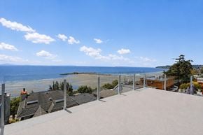 White Rock apartment for rent - A view of a beach from a rooftop terrace.