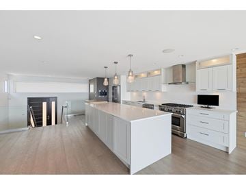 White Rock apartment for rent - A modern kitchen with white cabinets and a central island.