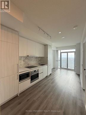 Vaughan (Vaughan Corporate Centre) condo for rent - A modern kitchen with wooden floors and white cabinets.