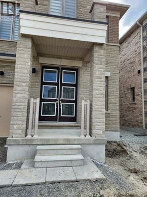 Whitchurch-Stouffville (Stouffville) apartment for rent - A house with a brown door and windows is under construction.
