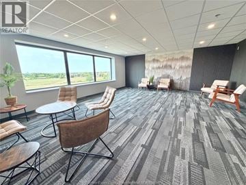 Lasalle condo for rent - A conference room with a grey carpet and wooden chairs.