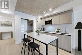 Toronto (Church-Yonge Corridor) condo for rent - A modern kitchen with a white countertop and black stools.
