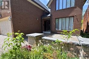 Pickering (Woodlands) apartment for rent - A house with a brick facade and a stone wall in front.