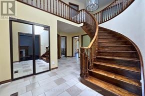 Pickering (Woodlands) apartment for rent - A wooden staircase with a glass balustrade leads to the upper floor of a house.