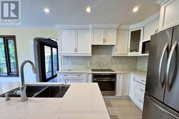 Pickering (Woodlands) apartment for rent - A kitchen with white cabinets and a stainless steel refrigerator.