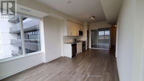 Hamilton (Beasley) condo for rent - A spacious living room with wooden flooring and a large window overlooking a balcony.