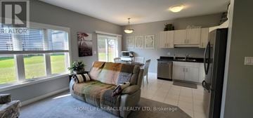 Pelham (Fonthill) townhouse for rent - A living room with a couch and a window overlooking a lawn.