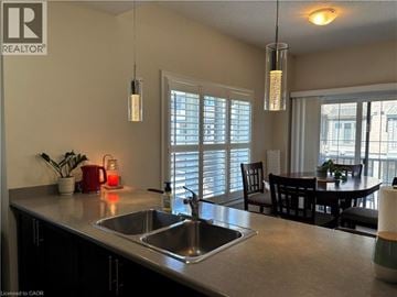 Stoney Creek townhouse for rent - A kitchen with a sink and a dining table.