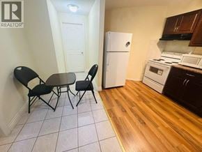 Coquitlam apartment for rent - A kitchen with a table and chairs in the foreground and a refrigerator in the background.