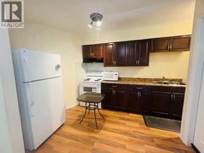 Coquitlam apartment for rent - A kitchen with a white fridge and wooden floors.