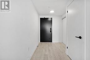 Burlington (Alton) condo for rent - A black door is in the middle of a white hallway.