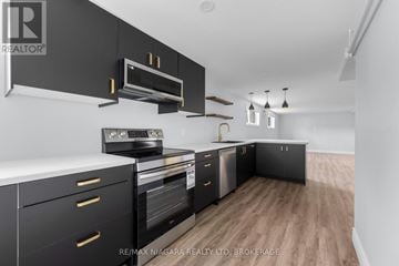 Pelham (Fenwick) multi-family for rent - A modern kitchen with black cabinets and stainless steel appliances.