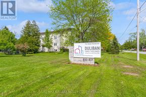 Pelham (Fenwick) multi-family for rent - A sign for Duluban Family Holdings stands in a grassy field.
