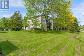 Pelham (Fenwick) multi-family for rent - A large, well-maintained lawn in front of a house with a tree in the foreground.