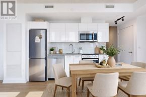 Toronto (Moss Park) condo for rent - A modern kitchen with a dining table set for two.