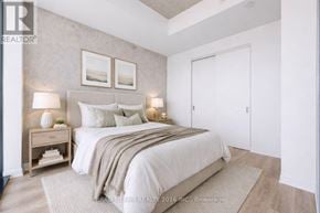 Toronto (Moss Park) condo for rent - A bedroom with a bed, nightstand, and two wall lamps.