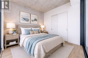 Toronto (Moss Park) condo for rent - A bedroom with a bed, nightstands, and a painting on the wall.