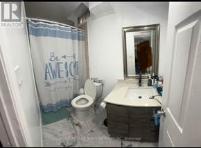 Ajax (Central West) apartment for rent - A bathroom with a toilet, sink, and shower curtain that says "Be AWESOME".