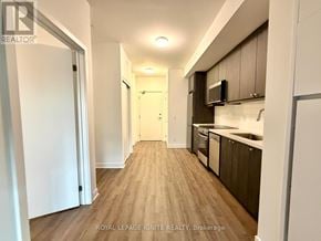 Clarington (Bowmanville) condo for rent - A well-lit hallway with wooden floors and modern appliances in a residential building.