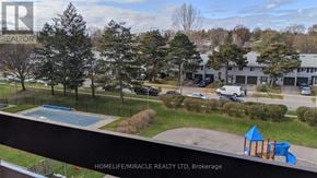 Mississauga (Applewood) condo for rent - A playground with a blue slide and a building in the background.