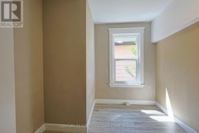London East (East G) fourplex for rent - A room with a window showing a view of a house and trees outside.