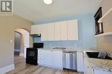London East (East G) fourplex for rent - A kitchen with white cabinets and a black stove top oven.