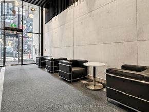 Toronto (Moss Park) condo for rent - A waiting area with black chairs and a grey carpet.