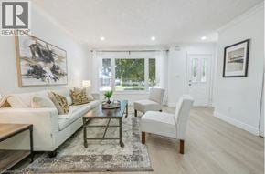 Guelph apartment for rent - A living room with a white couch, a coffee table, and a rug.