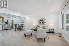 Guelph apartment for rent - A well-lit living room with a dining area and a kitchen in the background.