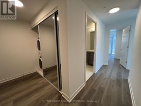 Toronto (Moss Park) condo for rent - A hallway with wood flooring and white walls.