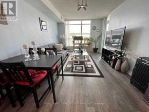 Toronto (Niagara) condo for rent - A living room with a black table and red chairs.