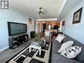 Toronto (Niagara) condo for rent - A living room with a grey couch and a black and white rug.