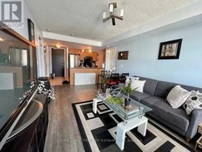 Toronto (Niagara) condo for rent - A living room with a grey couch and a glass coffee table.