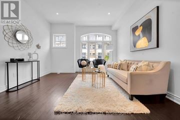 Mississauga (Streetsville) townhouse for rent - A living room with a beige couch, a white rug, and a painting on the wall.