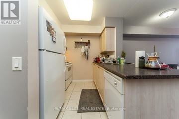 Toronto (Lansing-Westgate) condo for rent - A kitchen with a white refrigerator and wooden cabinets.