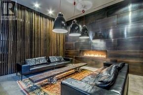 Toronto (Bay Street Corridor) condo for rent - A modern living room with a fireplace and a black leather couch.