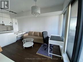 Toronto (Bay Street Corridor) condo for rent - A living room with a brown couch, a white coffee table, and a striped rug.