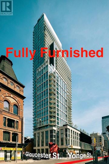 Toronto (Church-Yonge Corridor) condo for rent - A tall, modern building stands between two older buildings on a street corner.