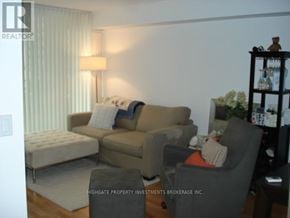 Toronto (Bay Street Corridor) condo for rent - A living room with a grey couch, a grey armchair, and a grey ottoman.